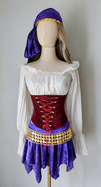 Mannequin wearing a costume with a white top, red corset, purple skirt, and purple headscarf.